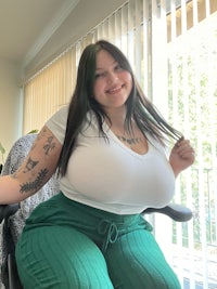 a woman sitting in a chair with a big tummy