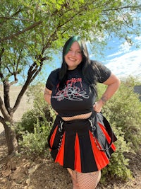 a woman wearing a black t - shirt and red skirt